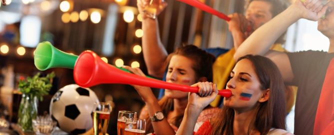 Jóvenes bebiendo y viendo un partido de fútbol en un Sports Bar de Barcelona